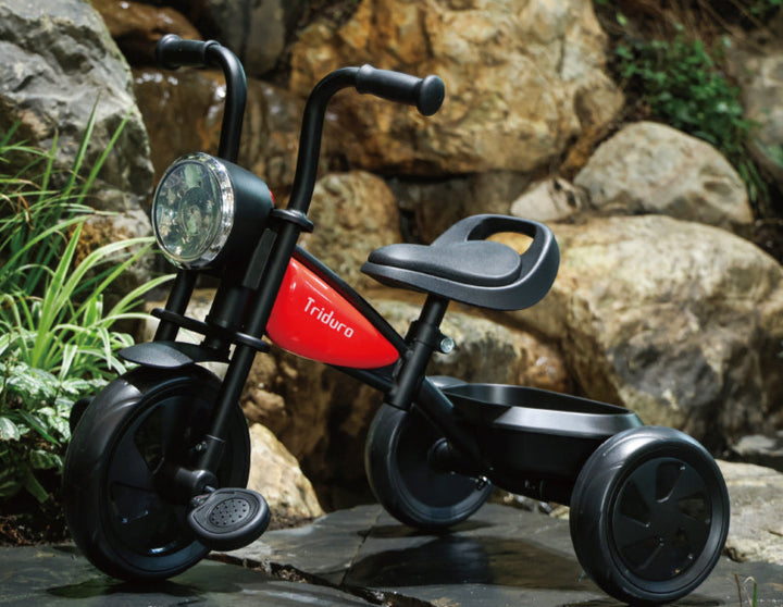 Black and red tricycle with 'Triduro' branding on a rocky surface.